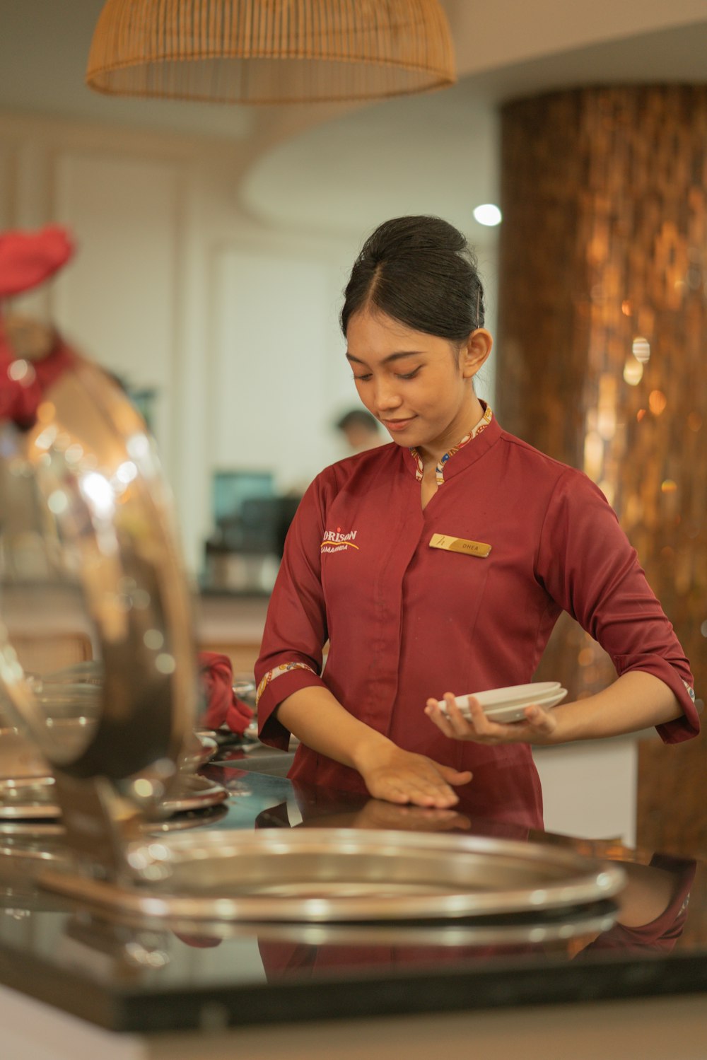 Eine Servicekraft bereitet im Restaurant Teller vor